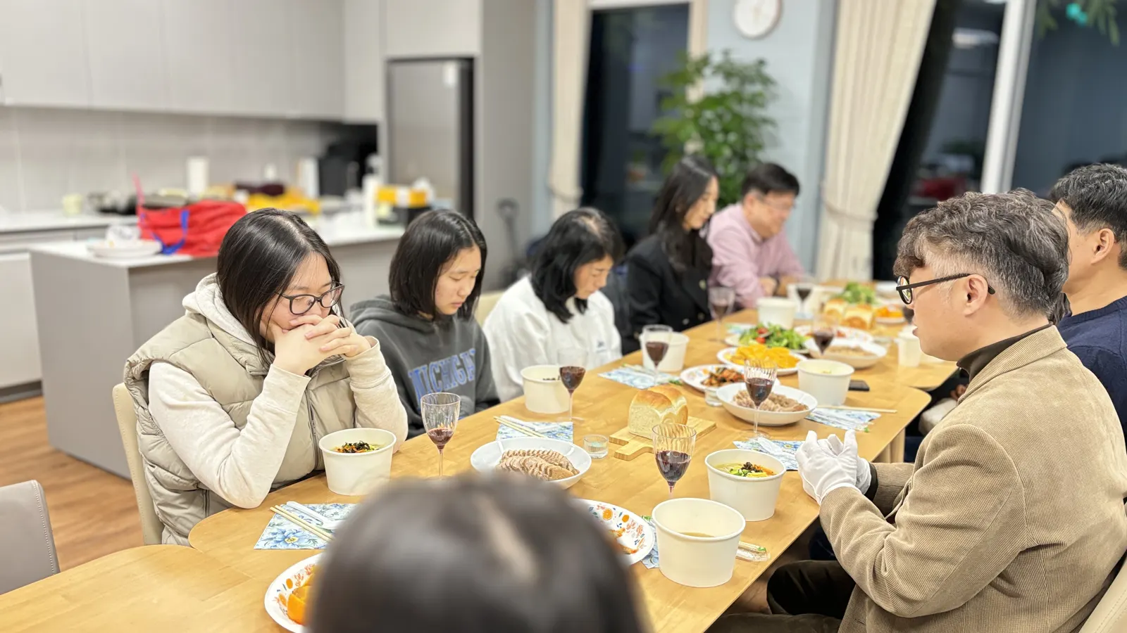 긴 식탁에 둘러앉아 식사하는 하늘누리교회 사람들